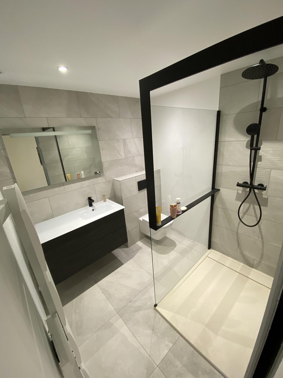 Salle d’eau avec paroi noire et meuble suspendu